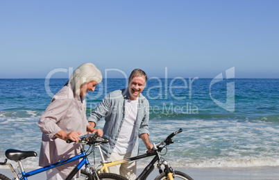 Retired couple with their bikes on the beach