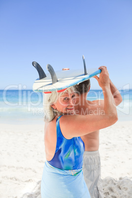 Senior couple with their surfboard