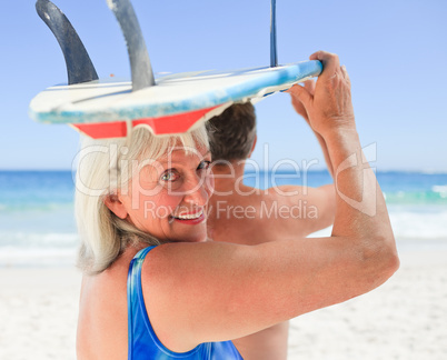 Senior couple with their surfboard