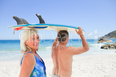 Senior couple with their surfboard