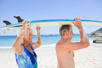 Senior couple with their surfboard