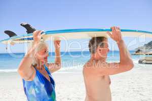 Senior couple with their surfboard