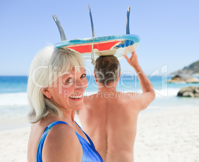 Senior couple with their surfboard