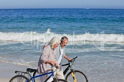 Retired couple with their bikes on the beach