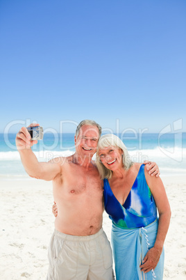 Couple taking a photo of themselves on the beach