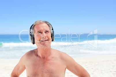 Retired man listening to some music on the beach