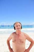Retired man listening to some music on the beach
