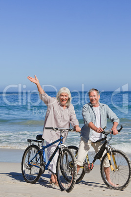 Mature couple with their bikes on the beach