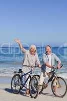 Mature couple with their bikes on the beach