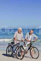 Mature couple with their bikes on the beach