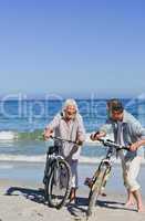 Mature couple with their bikes on the beach