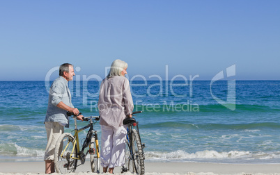 Senior couple with their bikes on the beach