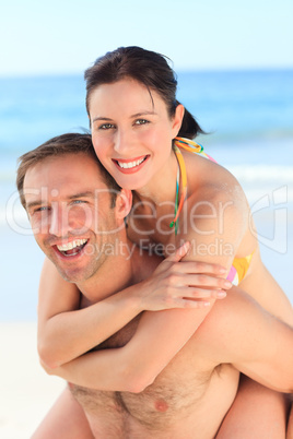 Man having wife a piggyback on the beach