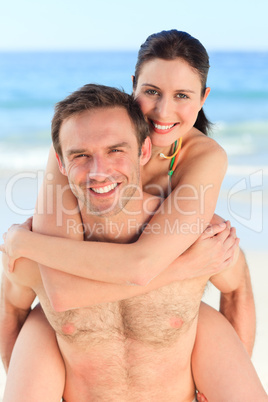 Man having wife a piggyback on the beach