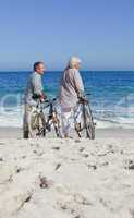 Senior couple with their bikes on the beach