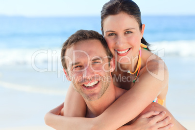 Man having wife a piggyback on the beach