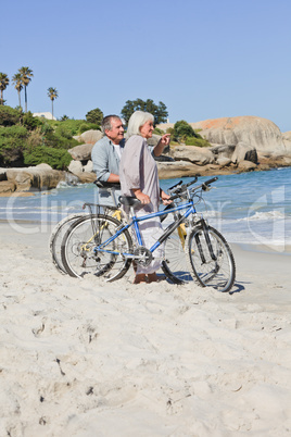 Senior couple with their bikes on the beach