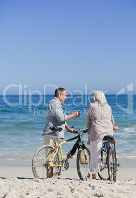 Senior couple with their bikes on the beach