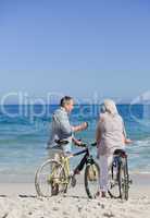 Senior couple with their bikes on the beach