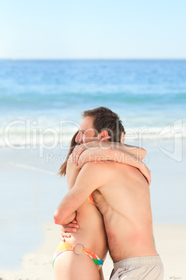 Adorable couple huging on the beach
