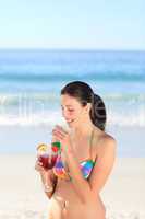 Beautiful woman drinking cocktail on the beach
