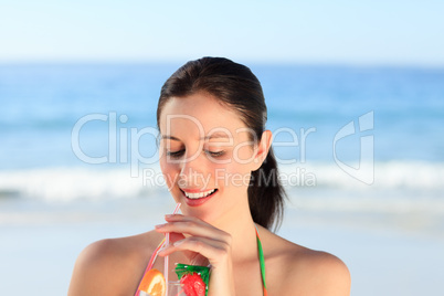 Beautiful woman drinking cocktail on the beach