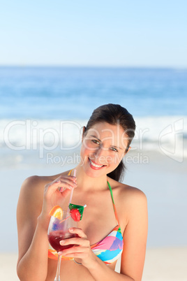 Beautiful woman drinking cocktail on the beach