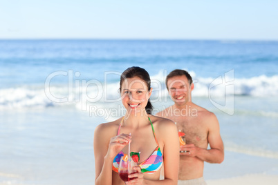 Couple drinking a cocktail on the beach