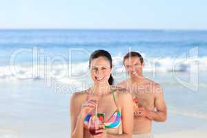 Couple drinking a cocktail on the beach