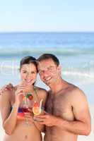 Couple drinking a cocktail on the beach