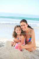 Daughter with her mother making a sand castle