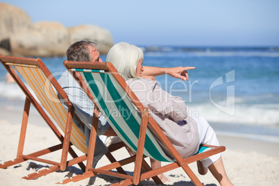 Retired couple sitting on deck chairs