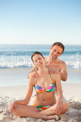 Attentive man applying sun cream on his girlfriend's back