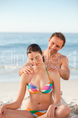 Attentive man applying sun cream on his girlfriend's back
