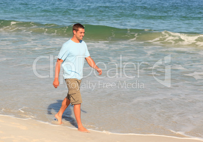 Handsome man walking on the beach