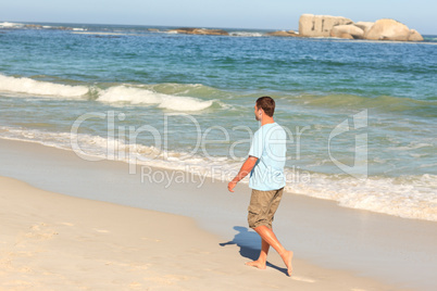 Handsome man walking on the beach