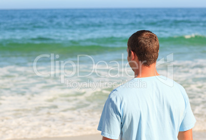 Handsome man walking on the beach