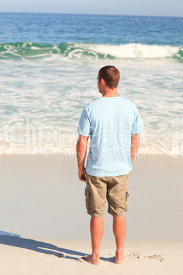 Handsome man walking on the beach