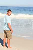 Handsome man walking on the beach