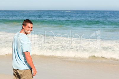 Handsome man walking on the beach