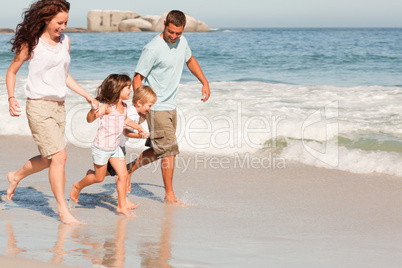 Family running on the beach