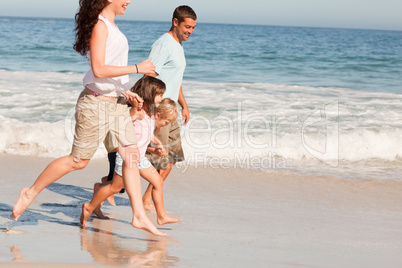 Family running on the beach