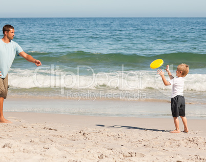 Little boy playing frisbee with his father