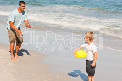 Little boy playing frisbee with his father