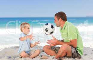 Happy father playing football with his son