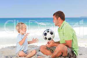 Happy father playing football with his son