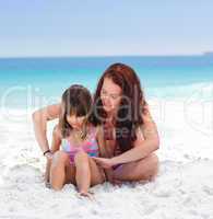 Mother applying sun cream on her daughter's back