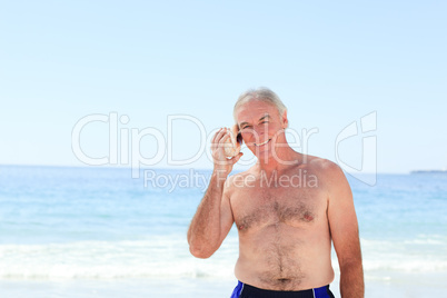 Senior man listening to his shell