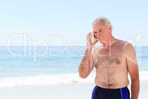 Senior man listening to his shell