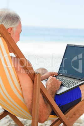 Man working on his laptop at the beach